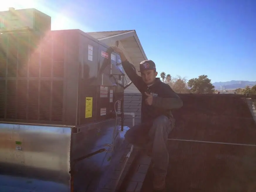 HVAC technician performing AC Tune-Up on a rooftop unit in North Canton